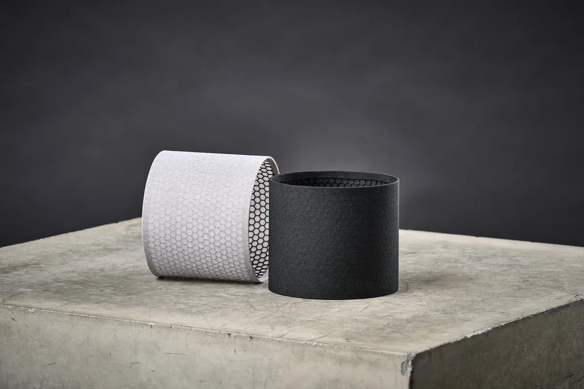 Funda textil Omni Cover puesta sobre un altavoz Omni, sobre fondo blanco.